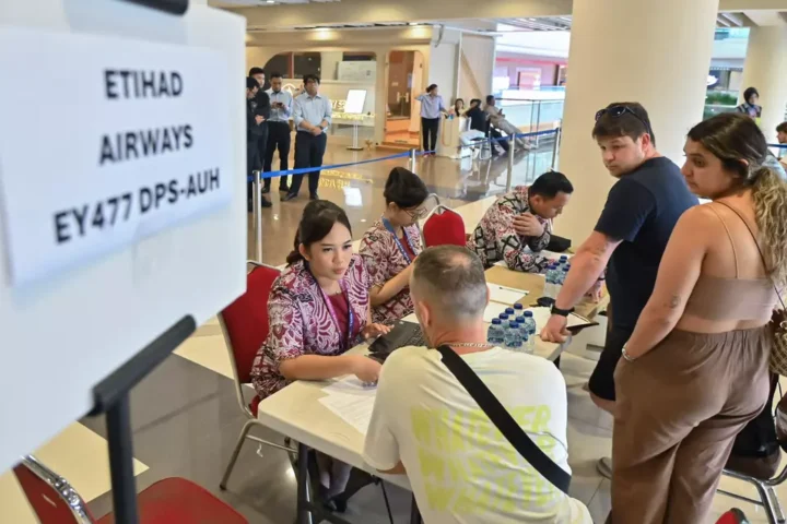 Staff assist passengers after Middle East flight cancellations at Bali’s Ngurah Rai