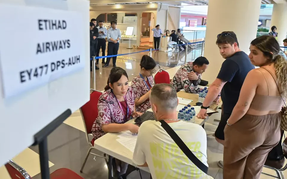 Staff assist passengers after Middle East flight cancellations at Bali’s Ngurah Rai